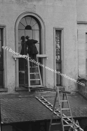 MAN FITTING LEADE GLASS AT RERE OF 35 LEESON STREET